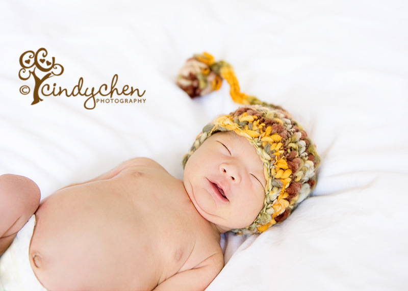 newborn baby smiling wearing a cute stocking cap